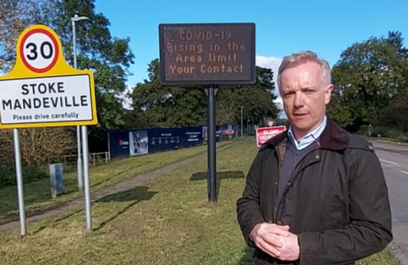 Rob in Stoke Mandeville next to sign reminding residents to follow Covid-19 rules