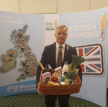 Rob Butler MP holds basket of foods